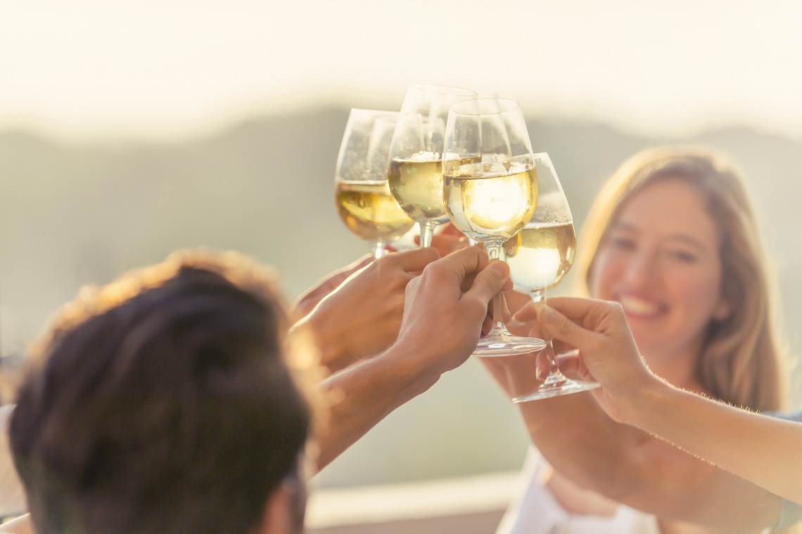 Group of friends raise glasses of white wine. Reinvigorating Marlborough Sauvignon Blanc