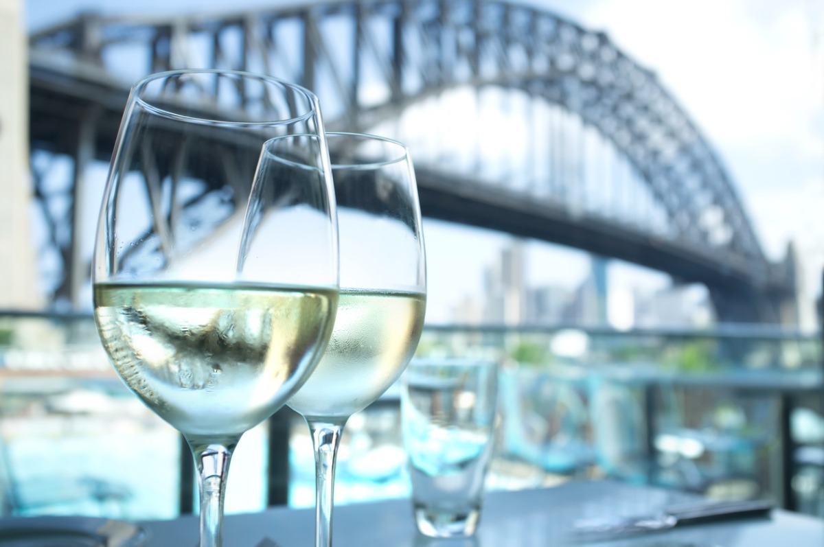 two glasses of wine in front of the Sydney Harbour Bridge