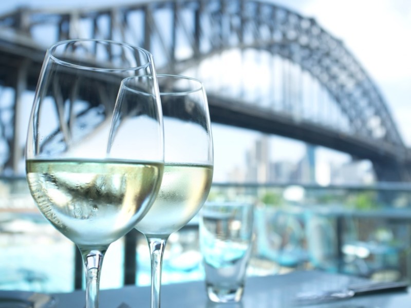 two glasses of wine in front of the Sydney Harbour Bridge