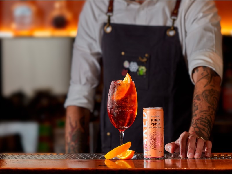 Bartender serves pre-mixed cocktail drink on-premise
