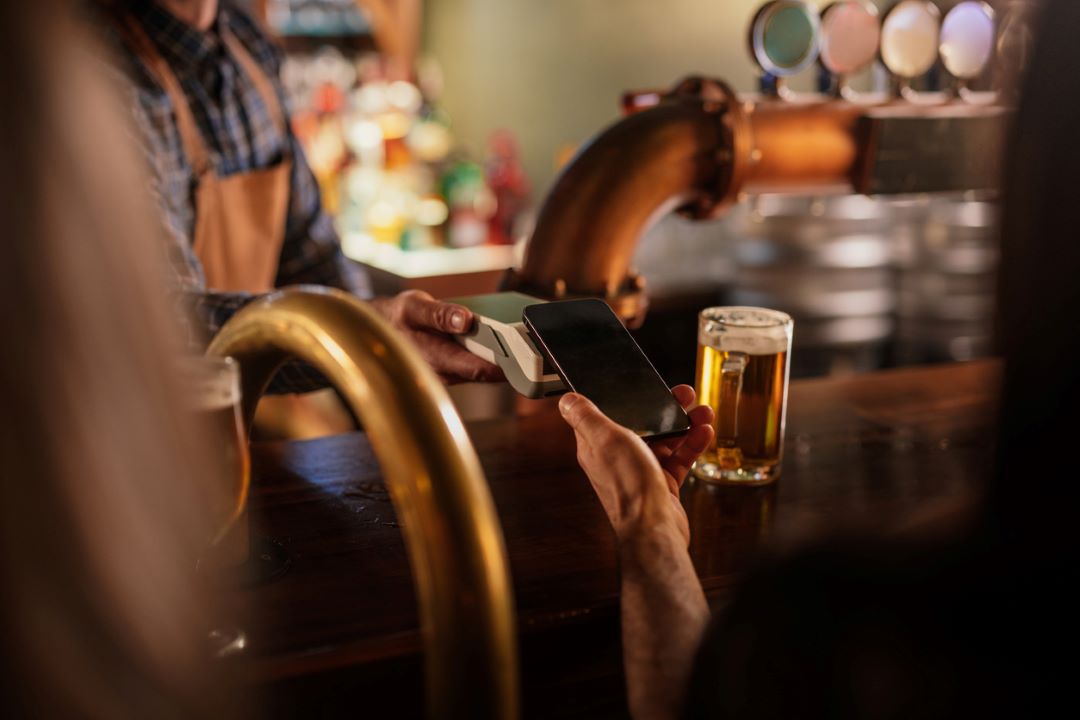 person tipping across a bar